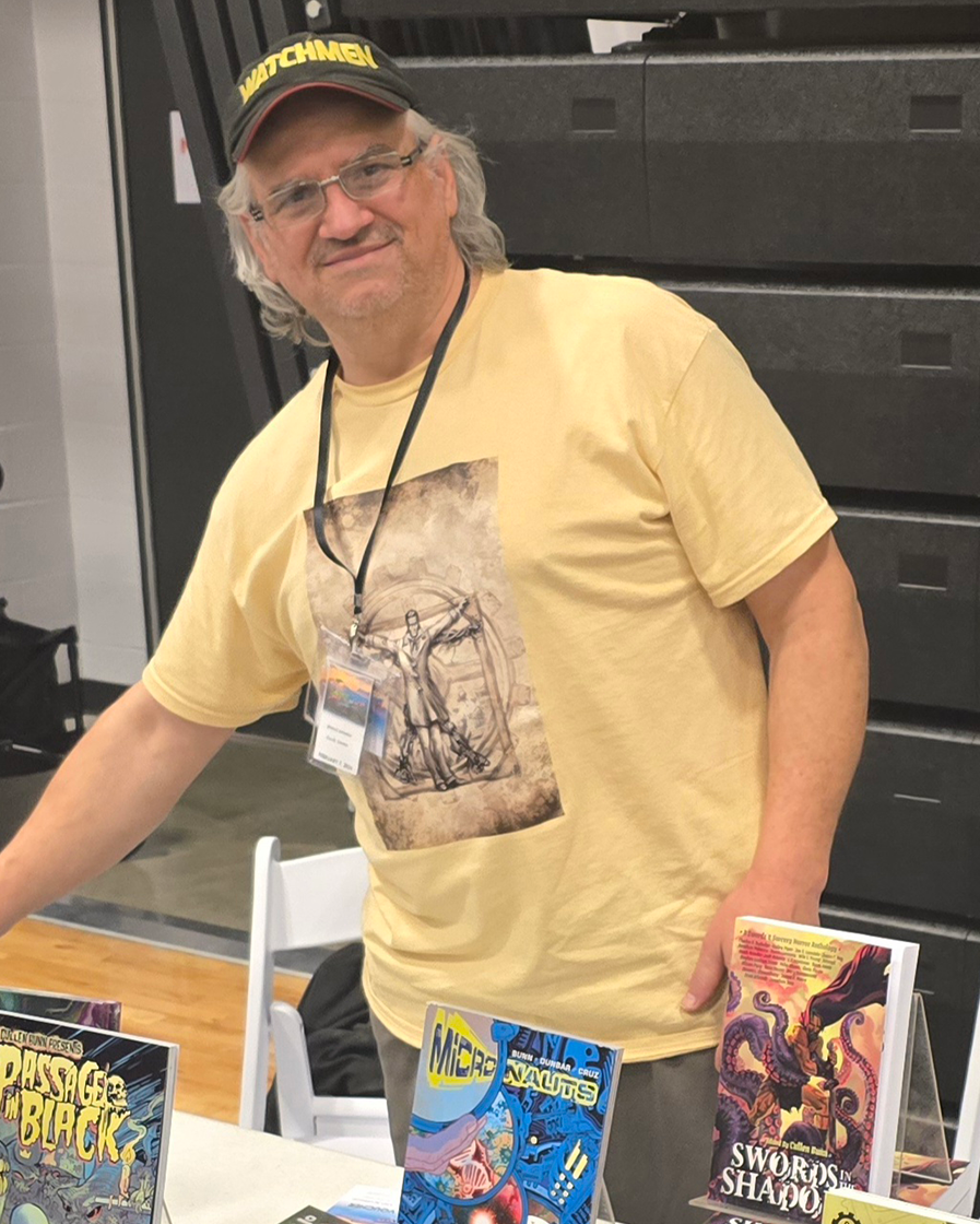 Photograph of JimmyZ smiling behind a display of books.